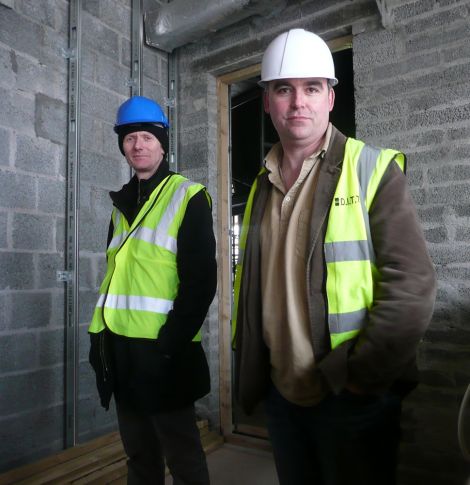 Shetland Arts director Gwilym Gibbons (right) and Mareel head of operations Richard Weymss standing where the back row will be in the cinema, while workmen are busy working on the wiring in the ceiling.
