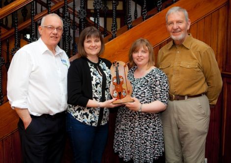 Cecil Hughson (left) and Gussie Angus (right) present competition organisers Vaila Grant and Valerie Watt with the new Catgut and Ivory trophy.