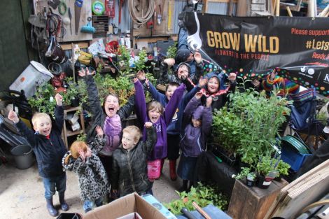 Kids from Urafirth primary school getting excited about Grow Wild at Hillswick, here on a rainy day with some of the plants for the native garden. Photo HWS