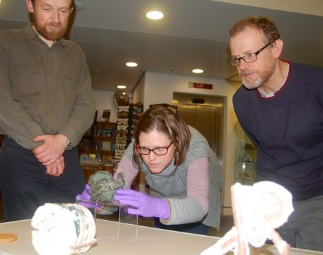 Imogen Gunn, collections manager from the Cambridge University Museum of Archaeology and Anthropology, places the bronze armlet on display under the watchful eyes of Shetland Museum curator Ian Tait and exhibitions officer John Hunter, who will be running bronze casting workshops for the two month duration of the exhibition.