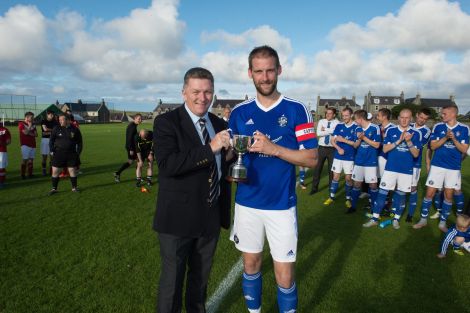 Captain Leighton Flaws receives the Ian Manson memorial cup from secretary of the Scottish Amateur Football Association Thomas Mckeown after being voted man of the match - Photo: Malcolm Younger
