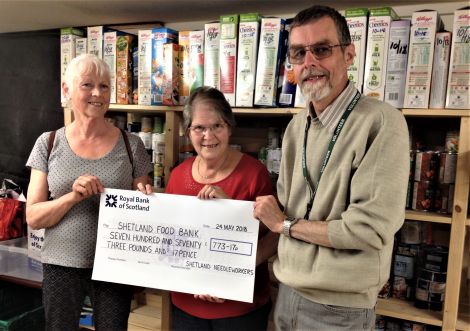 Christine Henderson and Helen Burgess donate a cheque to foodbank manager David Grieve.