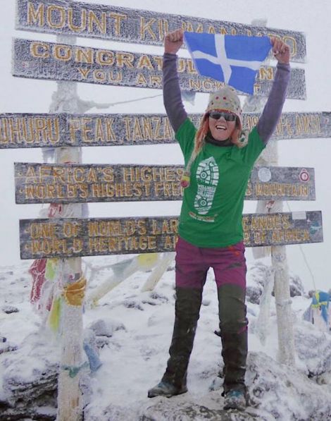 Anita Georgeson unfurling the Shetland flag at top of Africa.