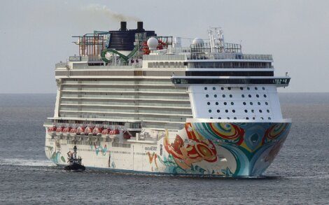 A large cruise ship adorned with vibrant artwork on its hull sailing on the ocean.