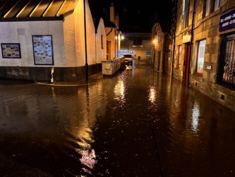 A city street is flooded at night.