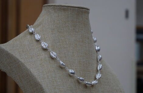 A silver necklace on a mannequin mannequin.