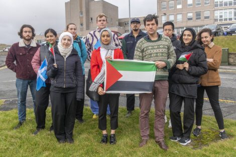 A group of people posing with a palestinian flag.
