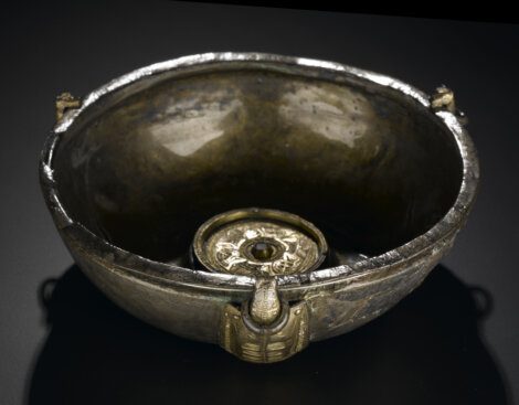 A gold bowl on a black surface.