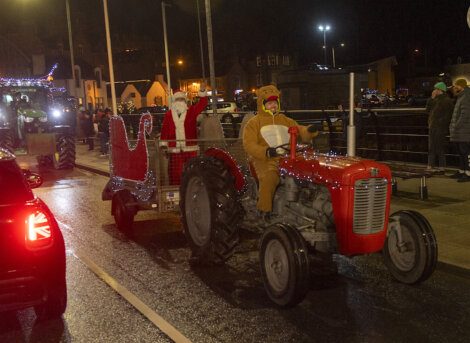A santa claus on a tractor.