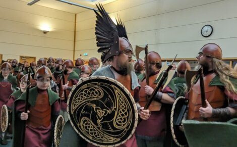 A group of people dressed as vikings in a room.