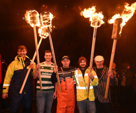 A group of men holding torches.