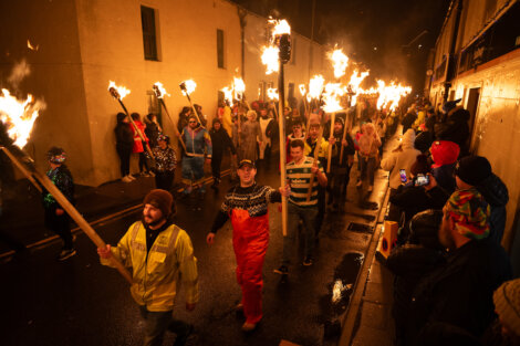 A group of people walking with torches.