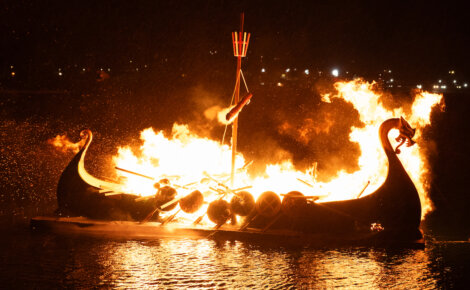 A boat on fire at night.