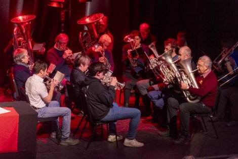 A group of people playing brass instruments on stage.