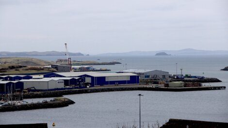 Industrial waterfront with warehouses and a view of the distant islands.