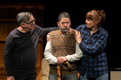Two actors comforting a distressed colleague on stage.